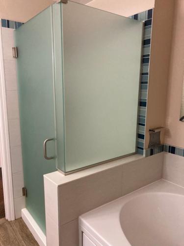 a bathroom with a glass shower with a sink at Sand Pebbles Inn in Cambria