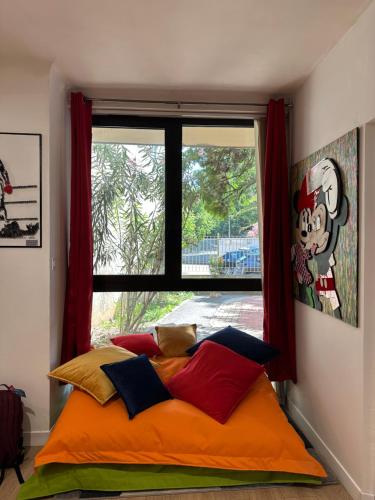 a bed in a room with a large window at POP appART Appartement Artiste 200 m du centre ville Parking privé gratuit in Avignon