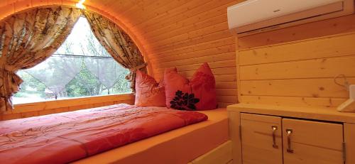 Bett in einem Zimmer mit Fenster in der Unterkunft Apple Tree Lodge in Lodè