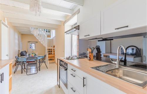 une cuisine avec des placards blancs et une salle à manger dans l'établissement 1 Bedroom Cozy Home In Avanton, à Avanton