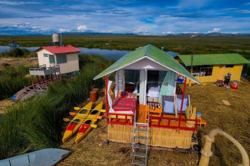 a gazebo with chairs and kayaks on a beach at Lake View Lodge in Puno