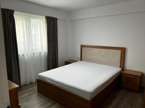 - une chambre avec un grand lit et une fenêtre dans l'établissement Apartament Monaco, à Roman