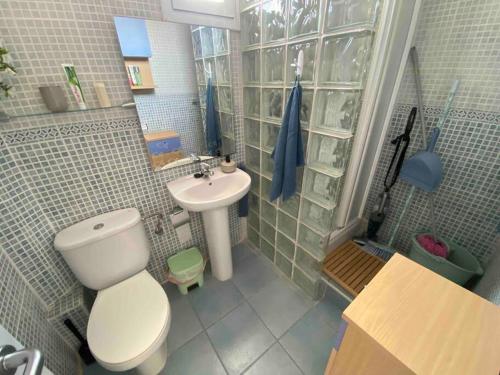 a bathroom with a white toilet and a sink at Coqueto ático con vistas al mar y a la montaña Auto Check-in in Miami Platja