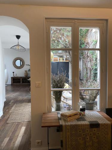a living room with a table and a large window at Artist's Home - Villa & Private Courtyard - 200m2 in Paris
