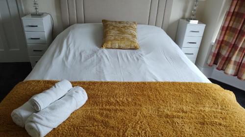 a bedroom with a bed with towels on it at Superior three bedroom house with sea view in Swansea