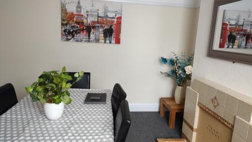 a room with a table with a potted plant on it at Superior three bedroom house with sea view in Swansea