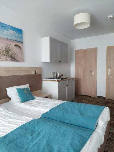 ein Schlafzimmer mit einem großen Bett mit blauer Bettwäsche in der Unterkunft Apartament Natalia -Welle in Grzybowo