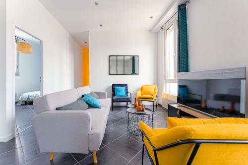 a living room with yellow and white furniture and a tv at Coeur de ville #B2 - Centre ville, WIFI & NETFLIX - Proche transports - CHAMBRE PRIVEE dans logement partagé in Cholet
