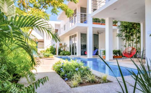 an exterior view of a house with a swimming pool at Maravilla Suites - Bucerias Golden Zone in Bucerías