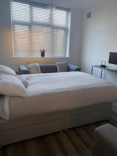 a large bed in a bedroom with a window at 2 bed flat with balcony, TV & Great transport in Edmonton