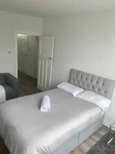 a bedroom with a white bed with a white headboard at 2 bed flat with balcony, TV & Great transport in Edmonton