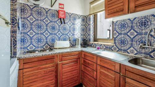 uma cozinha com armários de madeira e azulejos azuis e brancos em Peaceful Flat in Lagos by LovelyStay em Lagos