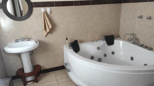 y baño con bañera blanca y lavamanos. en BINNAH GUEST ROOM, en Moyobamba