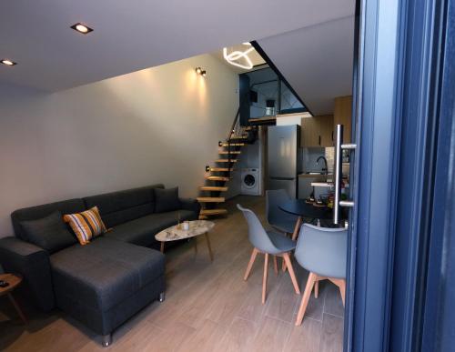 - un salon avec un canapé et un escalier dans l'établissement City Center Loft, à Kavala