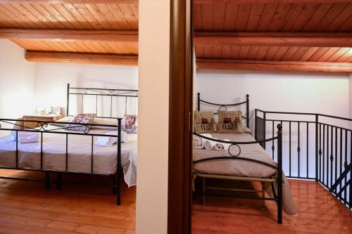 Un dormitorio con dos camas de hierro y una escalera. en Casa Acqua Veccia, en Noto