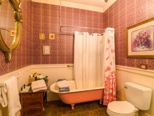 a bathroom with a tub and a toilet and a sink at The Steamboat Inn in Jefferson