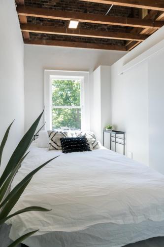 a bedroom with a large white bed with a window at The 505 Eugene in Eugene