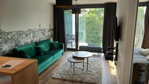 a living room with a green couch and a table at Art Apartamenty I Basen & SPA w CENTRUM z balkonem in Lublin