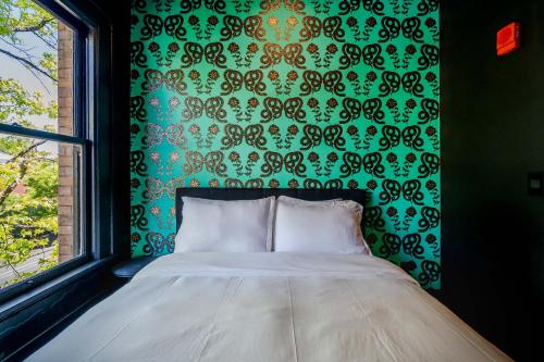 a bed in a room with a green wall at The 505 Eugene in Eugene