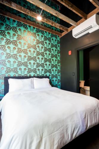 a bedroom with a white bed and a green wall at The 505 Eugene in Eugene