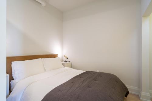 a bedroom with a large bed with white walls at The 505 Eugene in Eugene