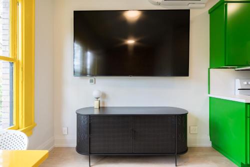 a living room with a large television on a wall at The 505 Eugene in Eugene