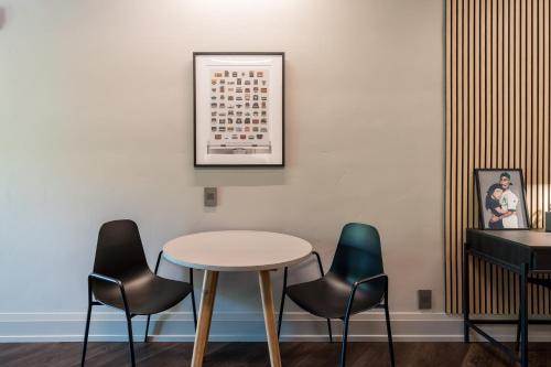 a table and four chairs against a wall with a picture at The 505 Eugene in Eugene
