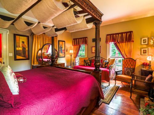 The Steamboat Inn في Jefferson: غرفة نوم مع سرير وردي كبير في غرفة