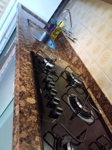 a kitchen counter with a bunch of wine glasses at Chalé alpino mobiliado perto do centro de canela rs in Canela