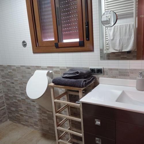 a bathroom with a sink and a toilet and a mirror at Ca Serrulleta in Ascó