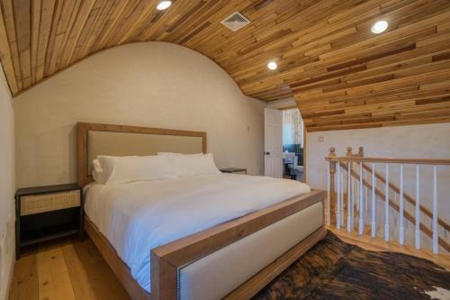 ein Schlafzimmer mit einem großen Bett und einer Holzdecke in der Unterkunft The Haüs Windham in Windham
