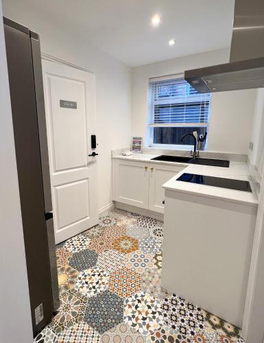 a kitchen with a sink and a tile floor at United Home B&B in Manchester