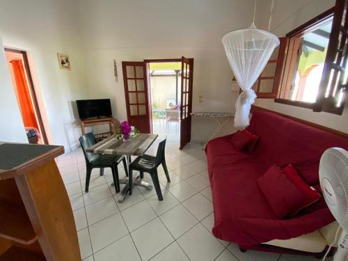 a living room with a red couch and a table at Gites VASSEAUX in Capesterre-Belle-Eau