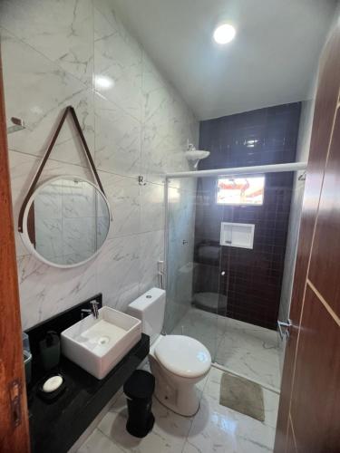a bathroom with a toilet and a sink and a shower at Nos Lençóis Dunas Residence 9 in Santo Amaro