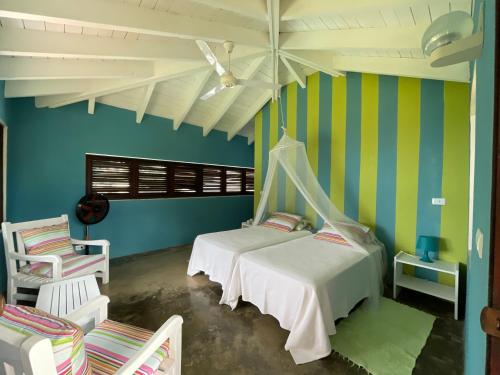 2 camas en una habitación con paredes azules y verdes en Guestroom los gorgones en Las Galeras