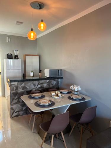 a kitchen with a table with plates on it at Nos Lençóis Dunas Residence 9 in Santo Amaro