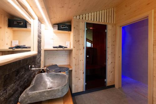 a bathroom with a sink in a wooden room at Mesnerhof my Paradise in Fiè