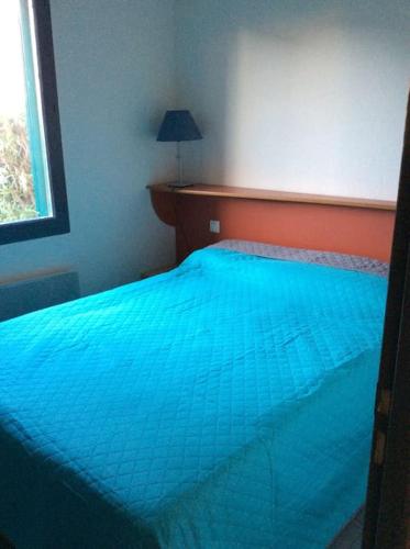 une chambre avec un lit avec une couette bleue dans l'établissement Maisonnette eau turquoise, à Argelès-sur-Mer