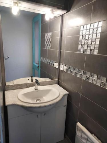 une salle de bain avec un lavabo et un miroir dans l'établissement Maisonnette eau turquoise, à Argelès-sur-Mer