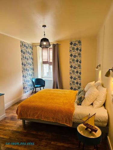 a bedroom with a bed and a chair and a window at Appartement La Roche-Bernard - 60m² plein centre in La Roche-Bernard