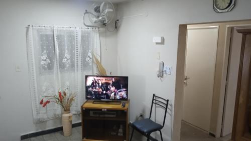 einen TV auf einem Stand in einem Zimmer mit einem Fenster in der Unterkunft Departamento Amplio con Terraza Exclusiva in Rosario