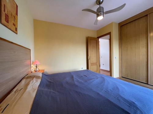 1 dormitorio con 1 cama azul y ventilador de techo en Adam Home Origo Mare, en Lajares
