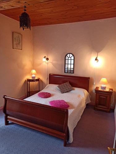 ein Schlafzimmer mit einem Bett mit zwei rosa Kissen darauf in der Unterkunft Maison familiale centenaire de vigneron in Montescot