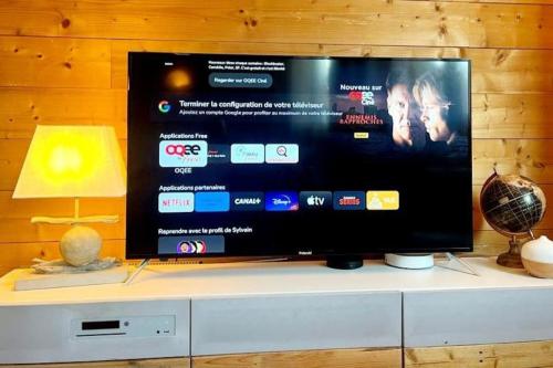 Elle comprend une télévision à écran plat installée au-dessus d'une armoire. dans l'établissement Le Bon appart, à Marlens