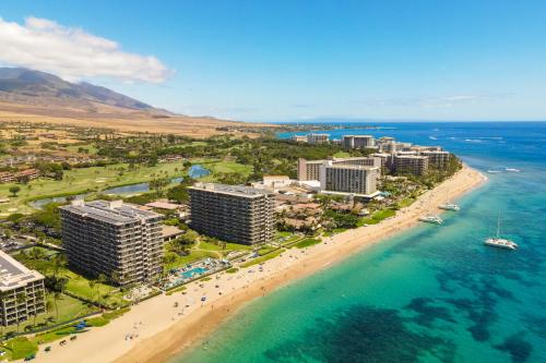 an aerial view of a beach with buildings and the ocean at The Whaler Resort in Lahaina