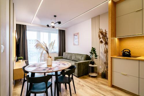 a kitchen and living room with a table and chairs at Apartament Czeslaw in Biała Podlaska