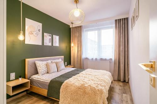 a bedroom with a bed and a green wall at Apartament Czeslaw in Biała Podlaska
