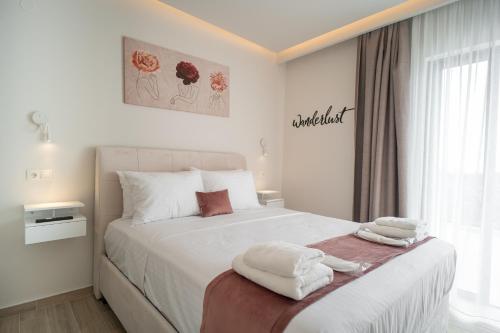 a bedroom with a white bed with towels on it at Central Palace Trikala in Tríkala