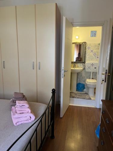 サンタ・テレーザ・ガッルーラにあるDa Adriana Guesthouseのベッドルーム1室(ベッド1台付)、バスルーム(シンク付)