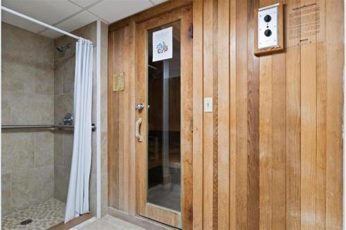 uma casa de banho com um chuveiro e uma parede de madeira em Holiday Surf and Racquet Unit 712 em Destin